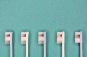 Saubere Zahnbürsten, die auf dem Hintergrund für den Beschriftungstext zur Mundhygiene ausgelegt sind