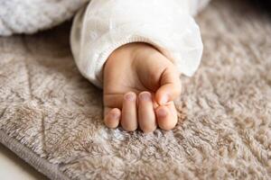 ein links Hand von Schlafen asiatisch Baby auf das Teppich foto