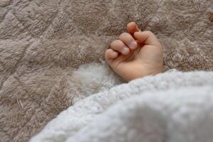 ein richtig Hand von Schlafen asiatisch Baby auf das Teppich foto