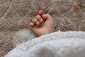 ein richtig Hand von Schlafen asiatisch Baby auf das Teppich foto