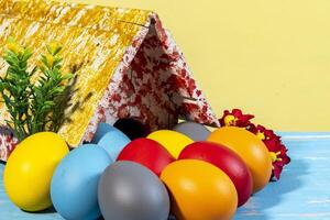 bunt Eier symbolisieren Ostern, mit ein Spielzeug Haus, Blumen mögen ein Garten foto