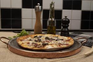 brasilianische pizza mit peperoni, käse, zwiebeln und schwarzen oliven foto