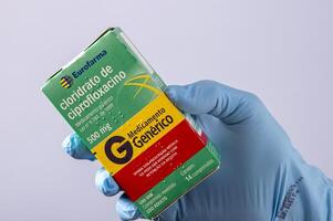 rio, brasilien - 27. januar 2023, hand mit schützendem gummihandschuh, der medikamentenbox hält, cipofloxacinhydrochlorid foto