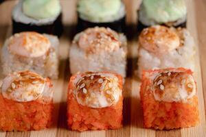 Satz Sushi-Rollen auf Serviertablett aus Bambus. Uramaki- und Futomaki-Rolle foto