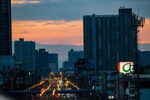 Bangkok, Thailand,2023 - - Dämmerung Antenne fotografieren von ein Metropole' Gebäude mit golden Himmel. das setzt sind kommerziell Geschäft Bezirke. foto