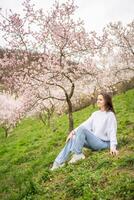 schön jung Frau im ein Blühen Rosa und Weiß Garten petrin im Prag, Frühling Zeit im Europa. hoch Qualität Foto