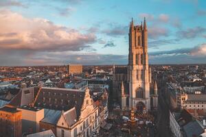 Aufpassen das Sonnenuntergang Über Gent von das historisch Turm im das Stadt Center. romantisch Farben im das Himmel. rot Licht leuchten Gent, Flandern Region, Belgien foto