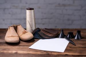 Leder Proben zum Schuhe und hölzern Schuh zuletzt auf dunkel hölzern Tisch. foto