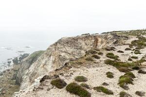 Sommer- atlantisch felsig Küste Aussicht groß steinig Steinschlag auf Abgrund Ufer und Ozean Surfen Wellen. Crozon, Frankreich Aussicht in der Nähe von das Denkmal Marine- Luftfahrt Kap von das Ziege kann 2018 foto