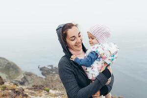 Mutter und wenig Tochter Stehen Felsen Ozean Strand Herbst Jahreszeit foto