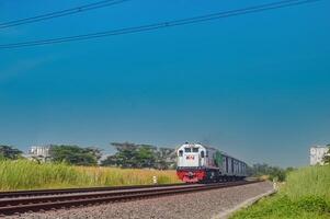 ein Serie von Ladung Züge mit Grün Wagen gezogen durch ein cc201 Lokomotive gemacht durch Allgemeines elektrisch Zugehörigkeit zu das indonesisch Eisenbahn Unternehmen, Indonesien, 28 Oktober 2023. foto