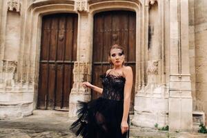 ein stilvoll Braut im ein schwarz Hochzeit Kleid posiert im das uralt Französisch Stadt von Avignon. Modell- im ein schön schwarz Kleid. Foto schießen im Provence.