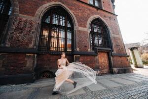 ein Braut im ein Hochzeit Kleid mit lange Haar im das alt Stadt, Dorf von Breslau. Hochzeit Foto schießen im das Center von ein uralt Stadt im polen.breslau, Polen