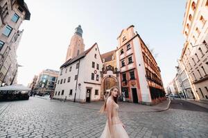 ein Braut im ein Hochzeit Kleid mit lange Haar im das alt Stadt, Dorf von Breslau. Hochzeit Foto schießen im das Center von ein uralt Stadt im polen.breslau, Polen