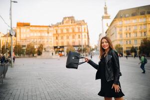 stilvoll jung Mädchen im ein schwarz Kleid und Jacke im das alt Stadt, Dorf von brünn. Tschechisch foto