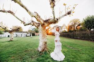 ein Braut im ein Weiß Hochzeit Kleid mit ein Gürtel im das alt Stadt, Dorf von Velden bin werter ein ... sehen Modell- im ein österreichisch Hochzeit Kleid.Alps foto