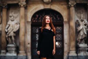 stilvoll jung Mädchen im ein schwarz Kleid im städtisch Stil auf das Straße von das Stadt von brünn. Tschechisch foto