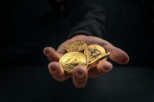 ein goldener Bitcoin in der Hand eines mysteriösen Mannes. foto