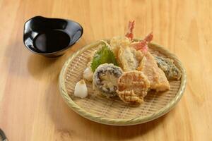 japanisch Essen Tempura Moriawase im ein hölzern Teller isoliert auf hölzern Tabelle oben Aussicht foto