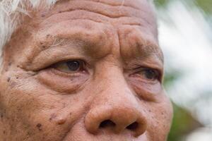 Nahansicht auf das Augen von ein Senior Mann. halbes Gesicht. Konzept von alt Menschen und Gesundheitswesen foto