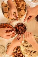 Hände nehmen Termine Obst oder Kurma, Konzept buka bersama, Teilen Essen während Ramadan Fasten Monat foto