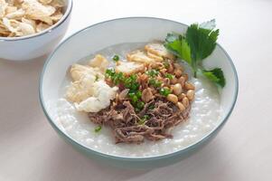 bubur daging krawu gresik enthält Weiß Reis Haferbrei mit Seite Geschirr von gebraten Hähnchen Scheiben foto