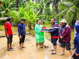 Pariaman, Indonesien - - März 8, 2024. Herr. regional Sekretär von Pariaman Stadt Hände Über Essen Hilfe zu Flut die Opfer im Norden Pariaman Kreis foto