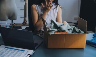 schön asiatisch Frau Blogger zeigen Tasche im Vorderseite von Kamera zu Aufzeichnung vlog Video Leben Streaming beim ihr shop.business online Influencer auf Sozial Medien Konzept. foto