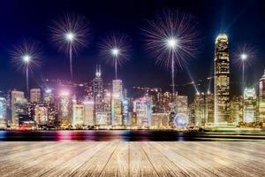 leerer Holzbohlenboden mit Feuerwerk über dem Stadtbild bei Nachthintergrund foto