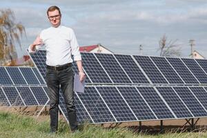 Solar- Paneele und Blau Himmelmann Stehen in der Nähe von Solar- Tafeln. Solar- Panel produziert Grün, ökologisch freundlich Energie von das Sonne. foto