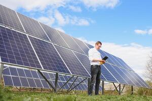 Solar- Paneele und Blau Himmelmann Stehen in der Nähe von Solar- Tafeln. Solar- Panel produziert Grün, ökologisch freundlich Energie von das Sonne. foto