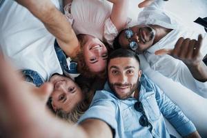 Afro-Amerikaner zeigen Daumen. junge Leute legen sich hin und machen ein Selfie foto