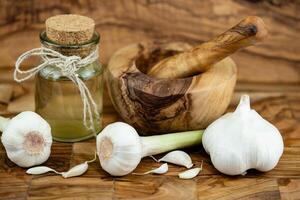 frisch Knoblauch zum Knoblauchöl auf Olive Holz foto