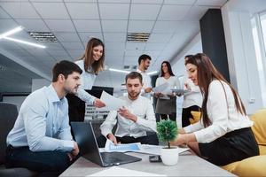 Vorderansicht. Gruppe junger Freiberufler im Büro unterhalten sich und lächeln foto