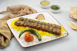 chelo oder chelo Kabab mit Reis, Tomate und Limette serviert im Gericht isoliert auf Tabelle oben Aussicht von arabisch Essen foto