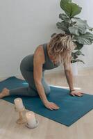 ein 50 Jahre alt Frau tut Yoga beim Zuhause foto