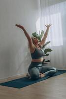 ein 50 Jahre alt Frau tut Yoga beim Zuhause foto