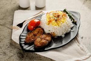 König Fisch mit Weiß Reis und Tomaten serviert im ein Gericht isoliert auf grau Hintergrund Seite Aussicht schnell Essen foto