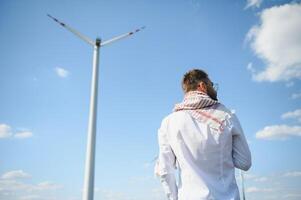 asiatisch oder arabisch Ingenieur Stehen gegen Windmühlen. foto