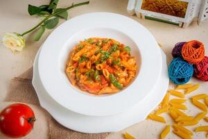 würzig Penne Masala Pasta zurückziehen Tomate im ein Schüssel isoliert auf Hintergrund Seite Aussicht foto