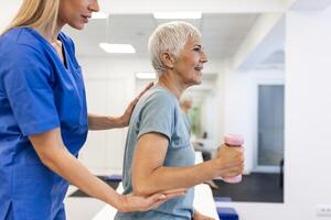 Fachmann Physiotherapeut Arbeiten auf Spezifisch Muskel Gruppen und zurück Schmerzen mit Senior weiblich. Frau erholen von mild Verletzung. Trauma Verhütung Therapie oder Rehabilitation beim Klinik foto