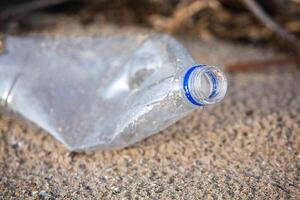 Plastik Flasche auf das Ufer von das See. Umwelt Verschmutzung. Plastik Abfall auf das Strand. foto