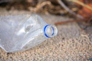 Plastik Flasche auf das Ufer von das See. Umwelt Verschmutzung. Plastik Abfall auf das Strand. foto