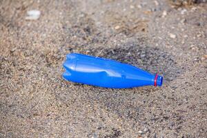 Plastik Flasche auf das Ufer von das See. Umwelt Verschmutzung. Plastik Abfall auf das Strand. foto