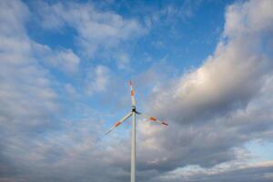 Wind Turbine auf das Hintergrund von das Blau Himmel. sauber verlängerbar Energie. elektrisch Leistung Produktion. foto