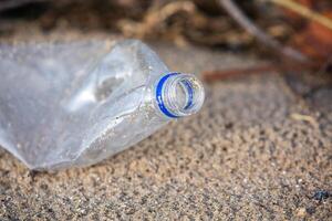 Plastik Flasche auf das Ufer von das See. Umwelt Verschmutzung. Plastik Abfall auf das Strand. foto