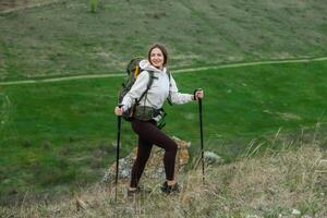 jung Frau mit Rucksack Wandern im das Berge. Wandern Konzept. Trekking Klippen. reisen, Reisender. foto