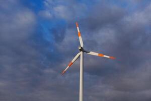 Wind Turbine auf das Hintergrund von das Blau Himmel. sauber verlängerbar Energie. elektrisch Leistung Produktion. foto