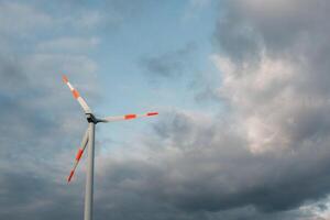 Wind Turbine auf das Hintergrund von das Blau Himmel. sauber verlängerbar Energie. elektrisch Leistung Produktion. foto