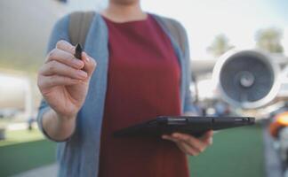 blond weiblich Tourist Überprüfung eingehend Benachrichtigung auf Smartphone Sitzung auf Sitz von Flugzeug mit Netbook.jung Geschäftsfrau Teilen Medien von Telefon auf Laptop Computer während Flugzeug Flug foto